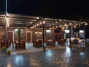 a patio with tables and chairs and lights at night at ร่มไม้สายธาร(Rommaisaitharn Resort) in Phrae
