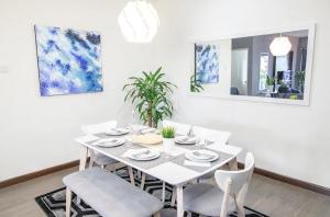 a white dining room with a white table and chairs at Omar's Place 1 in Kuala Lumpur