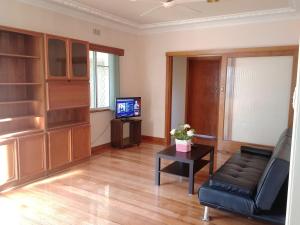 sala de estar con sofá y TV en Ideal Business and Family accommodation, en Dandenong