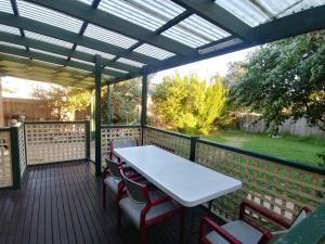 un patio con mesa y sillas en una terraza en Ideal Business and Family accommodation, en Dandenong