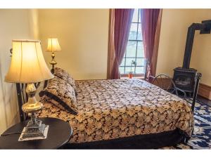 a bedroom with a bed with a lamp on a table at Culverdene House in Simcoe