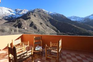 a balcony with chairs and a table and mountains at Aroumd Authentic Lodge Managed By Rachid Jellah in Imlil