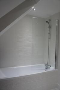 a bathroom with a tub with a shower and a sink at No 7 Woods View in Bournemouth