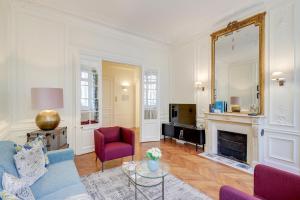 een woonkamer met een bank en een open haard bij Sweet Inn - Messine in Parijs