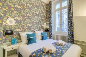 2 bedden in een slaapkamer met bloemenbehang bij Sweet Inn - Messine in Parijs