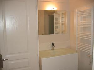 a bathroom with a sink and a mirror at Résidence Le Beau Site in Capvern