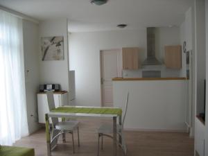 een keuken met een tafel en stoelen in een kamer bij Résidence Le Beau Site in Capvern