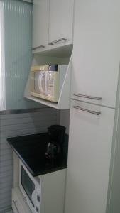 a small kitchen with a microwave on a counter at Frente Ao Mar in Santos