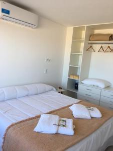 a bedroom with a large bed with towels on it at Mirasoles 20 in Las Gaviotas