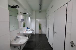 a bathroom with two sinks and a mirror at Elsässer Hostel in Hamburg