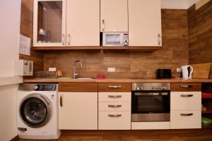 a kitchen with white cabinets and a washer and dryer at K&M Hostel in Hamburg