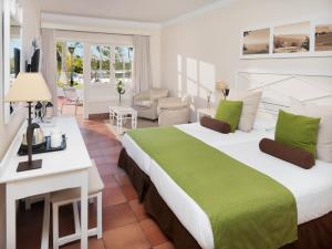 a bedroom with a large bed and a living room at Hotel Jardín Tecina in Playa de Santiago