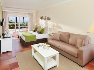 a living room with a bed and a couch at Hotel Jardín Tecina in Playa de Santiago