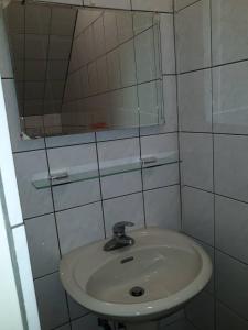 La salle de bains est pourvue d'un lavabo et d'un miroir. dans l'établissement Malaya Guest House, à Budai