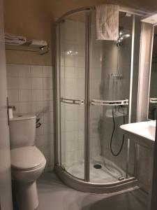 a bathroom with a shower with a toilet and a sink at Hotel du Centre in Gueugnon