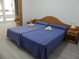 Un dormitorio con una cama azul con toallas. en Zeus Alexis, en Salou