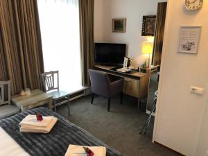 a hotel room with a bed and a desk with a computer at Hotel de Keizerskroon Hoorn in Hoorn