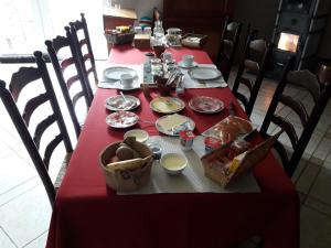 una mesa con un mantel rojo con comida. en B&B Mussenzele en Haaltert
