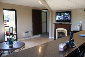 a living room with a fireplace and a tv on the wall at Cedar Inn in Lloydminster