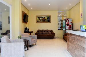 a living room with a couch and chairs at Hotel Glória in São Gabriel