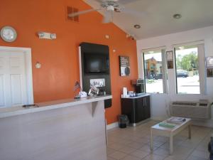 una sala de estar con una pared de color naranja y una mesa. en Motel 6-Willows, CA, en Willows