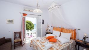 una camera da letto con un letto con cuscini arancioni e bianchi di Pension Ageliki Sifnos a Platis Yialos Sifnos