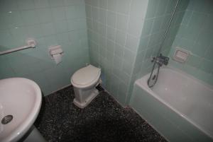 a bathroom with a toilet and a tub and a sink at Aries Basic in Salou