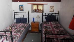 a bedroom with two beds and a table with a lamp at Casa Grøn in Breña Alta