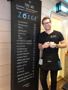 a man is standing in front of a sign at Stryn Kaffebar & Vertshus in Stryn