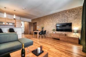 a living room with a couch and a tv at Apartman Lio in Vysoke Tatry - Tatranska Lomnica.