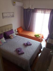 プレベザにあるMarilias Apartment Prevezaの紫色のタオルが付いたドミトリールームのベッド2台