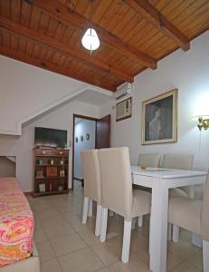 a dining room with a white table and chairs at Casamia Altos in Bahía Blanca