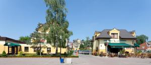 a street in a town with a tree and buildings at JANTAR-SPA Kompleks Wypoczynkowo-Rehabilitacyjny in Niechorze