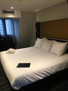 een bed met een zwart boek erop bij Hôtel Boutique Richelieu, Lyon Gare Part-Dieu in Lyon