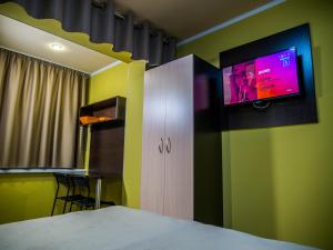 a bedroom with a tv on a green wall at Murmansk Discovery - Hotel Smart in Murmansk