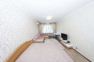 um pequeno quarto com uma cama e uma televisão em ATLANT Apartments 99 em Voronezh