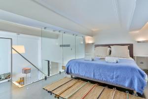 Schlafzimmer mit blauem Bett und Glaswänden in der Unterkunft Maison Bianchi - Duplex old town in Nizza