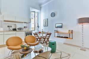 eine Küche und ein Wohnzimmer mit einem Tisch und Stühlen in der Unterkunft Maison Bianchi - Duplex old town in Nizza
