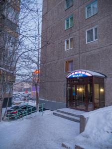 a phone booth in front of a building in the snow at Murmansk Discovery - Hotel Smart in Murmansk