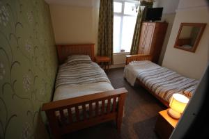 a bedroom with two beds and a window at Bay Court in Bridlington
