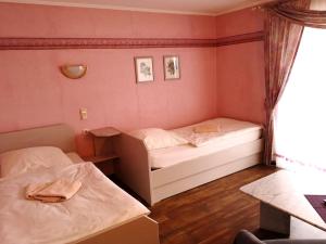 um pequeno quarto com 2 camas e uma janela em Gasthaus "Zur alten Dorfschmiede" em Metterich