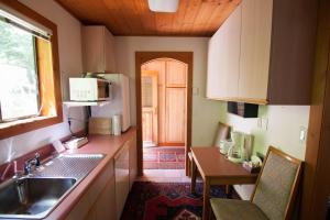 una piccola cucina con un lavello e un tavolo di Desolation Sound Resort a Lund