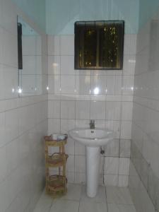 a white bathroom with a sink and a window at Machame Nkweshoo Cultural Tourism in Machame
