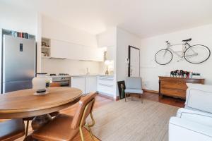a kitchen and living room with a table and a bike on the wall at Scrovegni Design Apartment in Padova