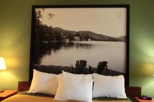 a bedroom with a large picture of a lake at Super 8 by Wyndham Queensbury Glens Falls in Queensbury