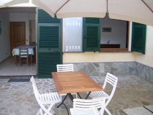 a wooden table with white chairs and an umbrella at Ariabuona in Moneglia