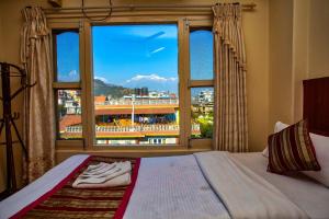 a hotel room with a bed and a window at Hotel Grand Holiday in Pokhara
