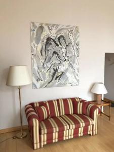 a living room with a couch and a painting on the wall at Hotel Villa Viktoria Luise in Blankenburg