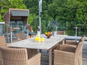 a wooden table with orange juice and a bowl of fruit at Paradise Cloud***** in Binz
