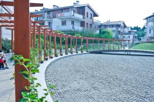 a brick walkway with a bridge and some houses at Grand Apartments - Neptun Park. in Gdańsk